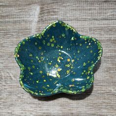 a green and yellow bowl sitting on top of a wooden table