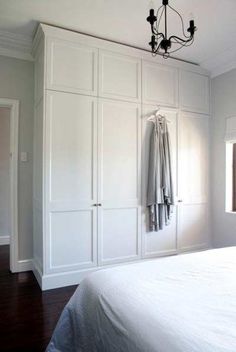 a bedroom with white closets and a chandelier