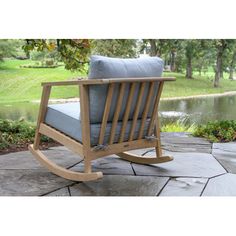 a wooden rocking chair sitting on top of a stone patio