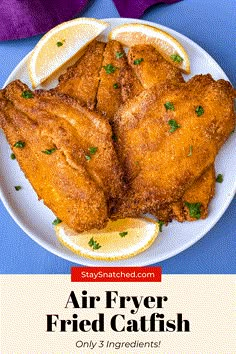 air fryer fried chicken on a plate with lemon wedges and parsley garnish