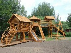 a wooden play set in the middle of a park