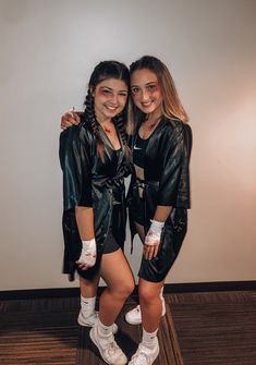 two girls in leather outfits posing for the camera