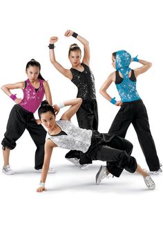 four young women are posing for a photo in their dance outfits and one is doing an acrobatic move