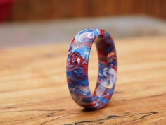 a colorful ring sitting on top of a wooden table