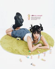 a woman laying on top of a green rug next to toy figurine figures