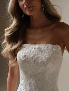 a woman in a wedding dress posing for the camera with her hand on her hip