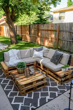 a couch made out of wooden pallets on a patio with pillows and throw pillows