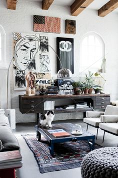 a living room filled with lots of furniture and pictures on the wall above it's coffee table