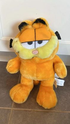 a yellow stuffed animal sitting on top of a tile floor