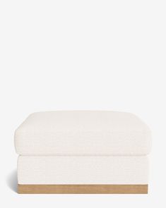 the footstool is made from white linen and wood, with a light colored finish