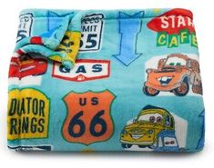 a blue blanket with cars, trucks and stars on it is folded up to show the name