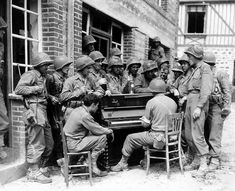 an old black and white photo of soldiers playing the piano