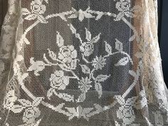 an old lace curtain with flowers on it