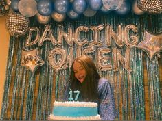 a woman standing in front of a birthday cake