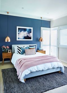 a bedroom with blue walls and white bedding