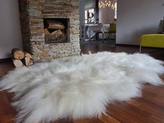 a white sheepskin rug in front of a fireplace