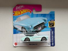 a blue and white hot wheels car is on the shelf next to it's packaging