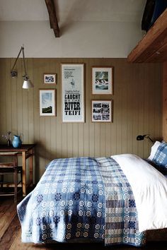 a bedroom with wood paneling and pictures on the wall