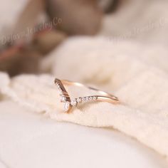 a diamond ring sitting on top of a white blanket