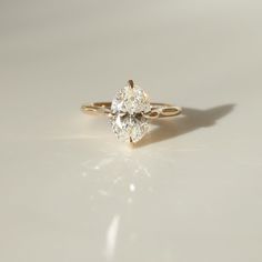 a close up of a diamond ring on a white surface