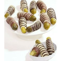 two white plates filled with chocolate covered pickles