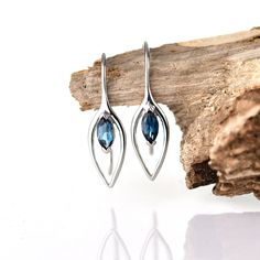 Sterling Silver London blue topaz elipse design dangle Earrings set with a marquise natural African marquise London blue topaz. Topaz are associated with love, self esteem and good fortune. They are the birthstone for December. Finished with a commercial grade rhodium plate to give a high quality shine finish. Supplied in an Ojewellery presentation box, within a ribbon handled gift bag, complete with product information authenticity card with space for a gift message and a jewellery cleaning cloth to keep your jewellery in ready to wear condition. Specification: Fastening:  Hook Earring Drop: 23.5mm Earring Width: 6.8mm Weight of pair:1.4g Stone: Natural African London Blue Topaz, 2 (1 per earring) marquise cut 6x3mm 0.4ct Metal mark: 925 for sterling silver Modern Blue Topaz Earrings For Gift, Modern Sapphire Gemstone Earrings, Modern Sapphire Sterling Silver Earrings, Mother In Law Birthday, Gift Message, December Birthstone, Good Fortune, London Blue Topaz, London Blue