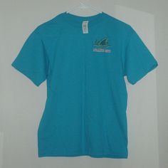 Margaritaville Landshark Surf Shack Atlantic City Double-Sided, Turquoise Colored T-Shirt. Brand New With $18.95 Price Tag And In Size Large. Other Approximate Measurements: 18" Pit To Pit, 18 1/2" Waist And 25" Length. Casual Blue Surfing Shirt, Blue Short Sleeve Tops For Surfing, Casual Cotton T-shirt With Shark Design, Summer Short Sleeve T-shirt With Shark Design, Casual Short Sleeve Shark Design Tops, Casual Short Sleeve T-shirt With Shark Design, Casual Short Sleeve Top With Shark Design, Casual Summer T-shirt With Shark Design, Summer T-shirt With Shark Design, Short Sleeve