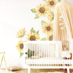 a baby's room with sunflowers painted on the wall and crib