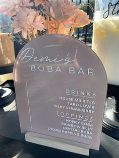 there is a sign that says drink boba bar next to some candles and flowers