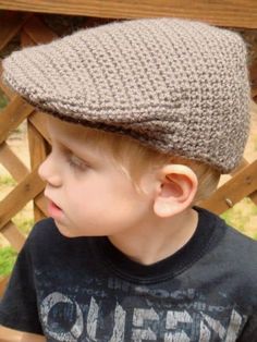 a young boy wearing a knitted hat on top of his head