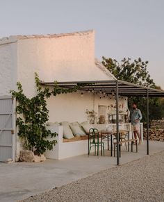 a man sitting at a table in front of a white building