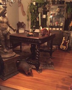 there is a statue on the table in the living room with other items around it