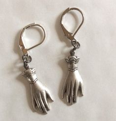 A pair of elegant hands two hand earrings created from two Victorian styled findings silver tone charms. These earrings hang from the cuff For pierced ears with leverback fittings Perhaps a present for an engagement or wedding with the emphasis on hands in both celebrations.  Please note that the hands are identical and therefore not a true 'pair' of hands, but good for giving a virtual hug The charms are single sided stamped metal and are therefore hollow backed and lovely and light to wear Measurement hand 2.5cm long each  See other hand and eye jewellery Silver Dangle Hoop Earrings With French Hook, Silver Hoop Earrings With French Hook, Silver Lever Back Jewelry Gift, Silver French Hook Jewelry For Wedding, Silver Lever Back Jewelry As Gift, Silver Lever Back Jewelry For Gift, Silver Clip-on Dangle Jewelry, Adjustable Silver Jewelry With Lever Back, Silver Dangle Clip-on Jewelry