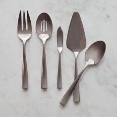 five spoons and two forks on a marble surface