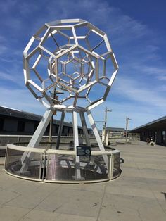 a large metal sculpture sitting on top of a cement ground