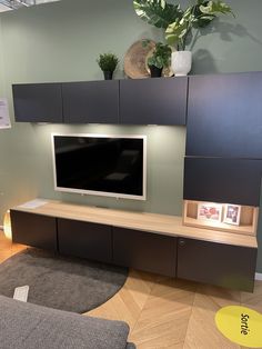 a flat screen tv sitting on top of a wooden entertainment center in a living room