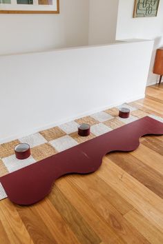 three bowls on the floor in front of a white wall