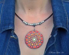 a woman wearing a necklace with an orange and blue design on it