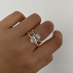 a woman's hand with a ring on it that has two stones in the middle