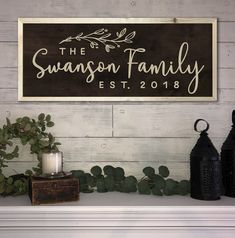 a wooden sign that says the swanson family on it next to candles and plants