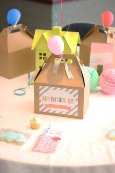 a table topped with small boxes and balloons