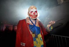 a man dressed in clown makeup holding a knife