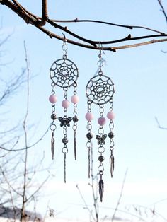 a pair of earrings hanging from a tree branch