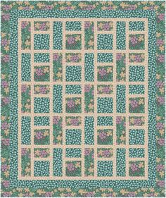 a green and pink quilt with flowers on the border, in front of a white background