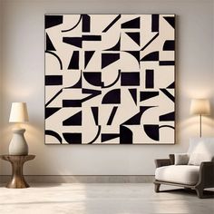 an abstract black and white painting hangs on the wall above a chair in a living room