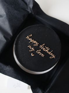 a birthday cake with writing on it in a black gift bag that says happy birthday, my love