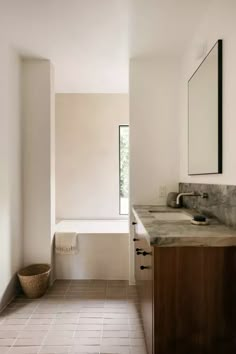 a bathroom with a sink, mirror and bathtub in the middle of the room