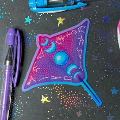 A sticker in the shape of a manta ray. The ray is purple and pink, and has blue moon phases along their back. The 12 constellations of the zodiac accent the ray's fins. Twilight Moon, Stationary Craft, 90s Art, Glassine Bags, Manta Ray, Pink Moon, Paint Marker, Die Cut Stickers, Cut Stickers