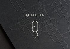 the logo for qualia is shown in white on black paper with an intricate design