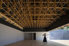 a woman is standing in an empty room with wooden rafters on the ceiling and walls